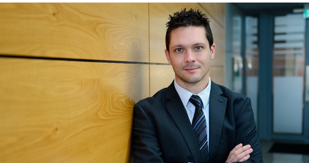 Dr Kevin McGuinness DCU, standing beside wood panelling in a corridor