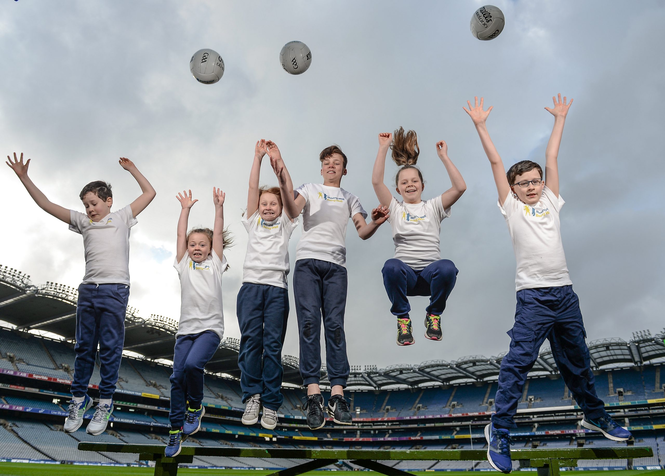 Kids jumping with footballs