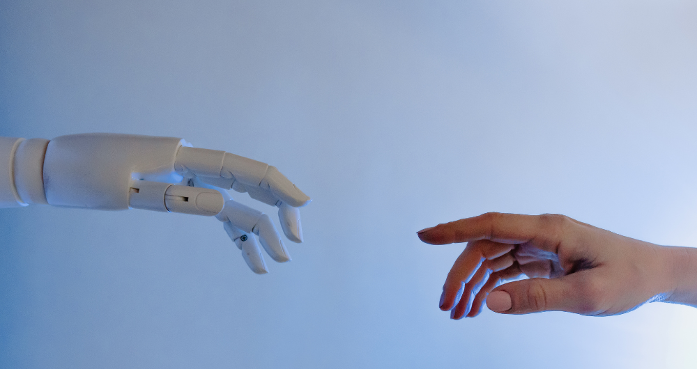 A robotoc hand reaches out to touch a human hand