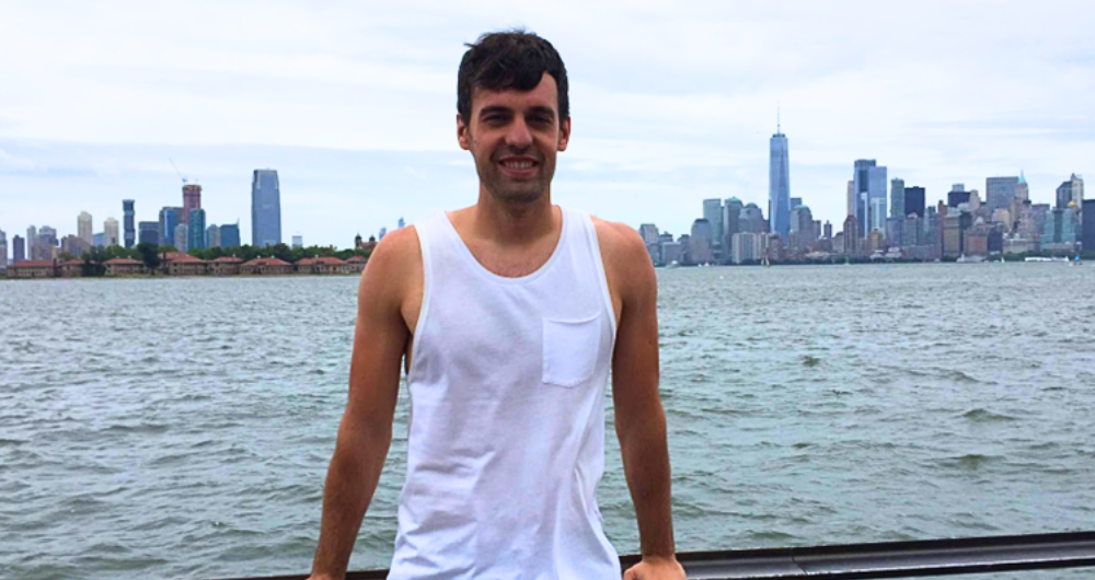 Insight alum david Azcona standing against a railing with water and the New York skyline in the background