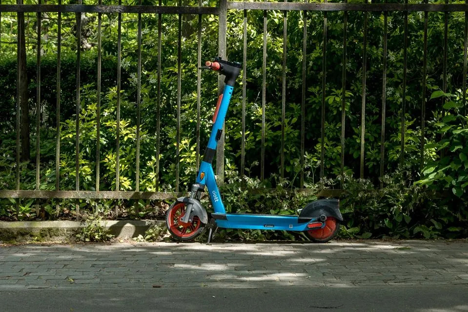 Blue scooter in front of fence