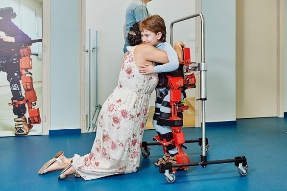 Child being hugged while in exoskeleton